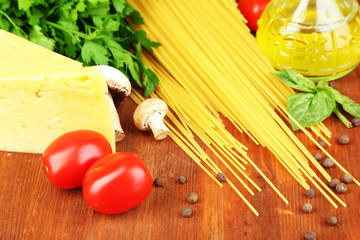 Pasta with oil, cheese and vegetables on wooden table close-up