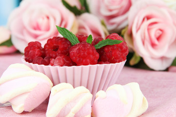 Fresh raspberry on wooden  table, on bright background