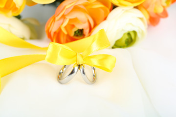 Wedding rings tied with ribbon on white fabric