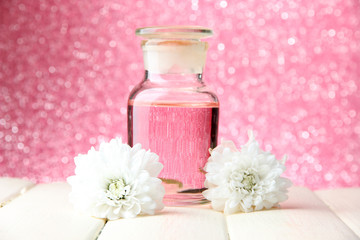 Fototapeta na wymiar Glass bottle with color essence, on pink background