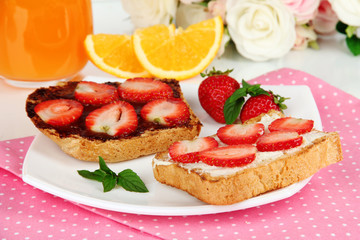 Delicious toast with strawberry on plate close-up