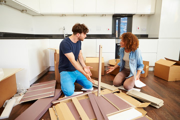 Couple Putting Together Self Assembly Furniture In New Home - obrazy, fototapety, plakaty