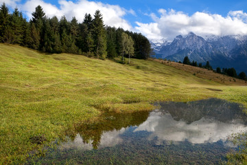 Fototapeta na wymiar wysokie Alpy i błękitne niebo odzwierciedlenie w dzikim jeziorze