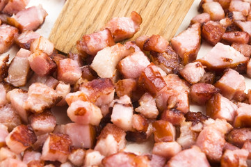 Macro photo of bacon being fried in a pan