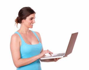 Fototapeta premium Sporty woman working on laptop while standing