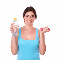 Smiling female lifting weights and water bottle