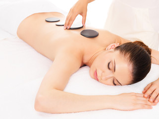 Obraz na płótnie Canvas Woman having hot stone massage in spa salon.