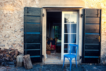 Fototapeta na wymiar Niebieskie krzesło przed wejściem w pięknym domu Provance