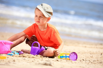 boy playing toys on beach