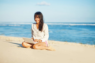 Fototapeta na wymiar woman with laptop on a beach 