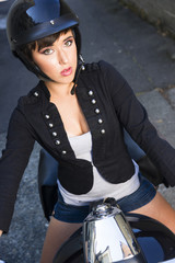 Obraz na płótnie Canvas Motorcycle Rider Attractive Female Leaves Garage into Back Alley