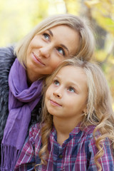 Happy mum and the daughter play autumn park