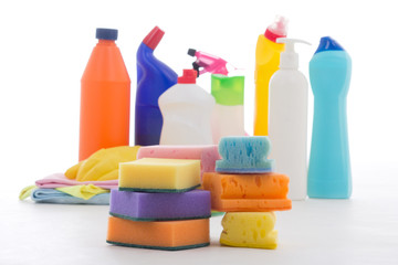 Plastic bottles of cleaning products and sponges isolated on whi