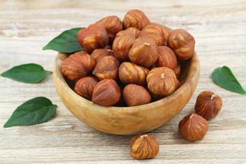 Whole hazelnuts without shell in wooden bowl
