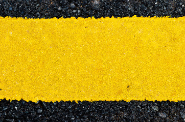 Closeup rough yellow paint on asphalt road