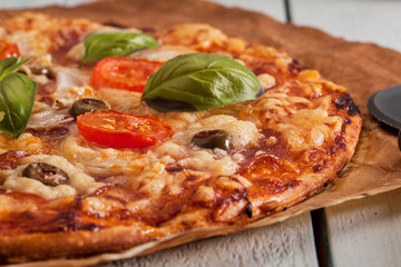 Pizza with salami, tomatoes and olives