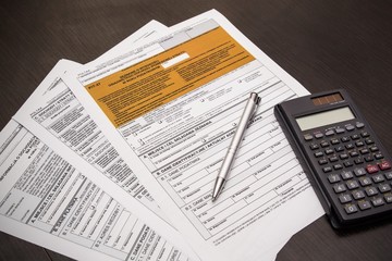 Polish tax form with pen and calculator on desk