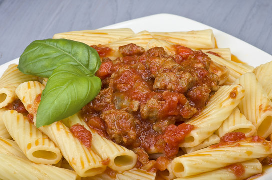 A dish of Maccheroni pasta with tomato souce and sausage