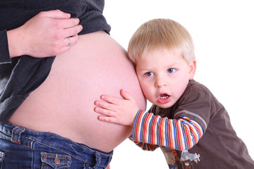 kleinkind horcht am babybauch