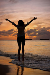 Fototapeta premium Silhouette of a girl at sunset near the shore of Indian Ocean