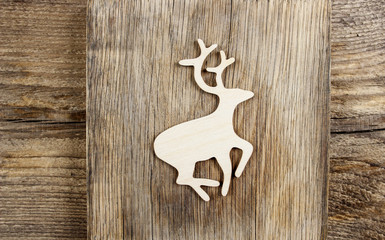 Deer shape made of wood on wooden table. Christmas decor.