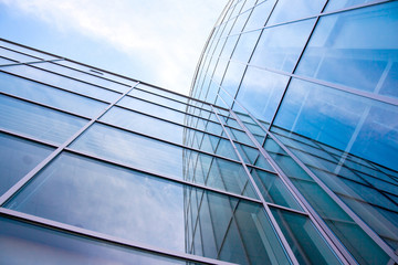Fototapeta na wymiar facade of modern glass blue office and clouds