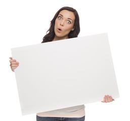 Fototapeta premium Wide Eyed Mixed Race Female Holding Blank Sign on White.