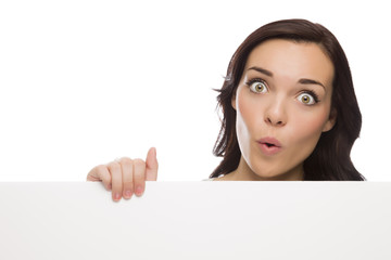 Fototapeta premium Wide Eyed Mixed Race Female Holding Blank Sign on White.