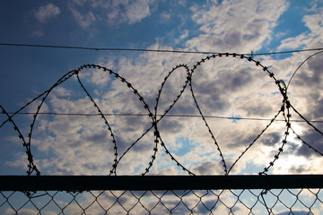 fence with barbed wire against the sky