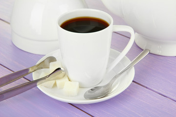 Cup of coffee, teapot and sugar-bowl on color wooden background