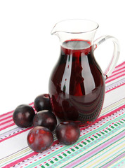 Delicious plum juice on table on white background