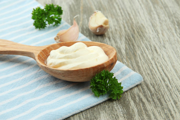 Sour cream in spoon on table close-up