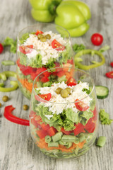Tasty salad with fresh vegetables on wooden table