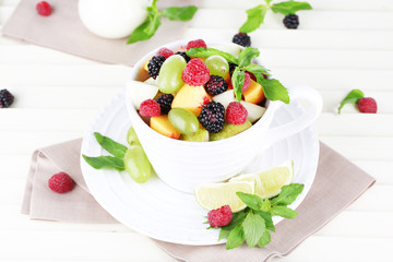 Fruit salad in cup on wooden table