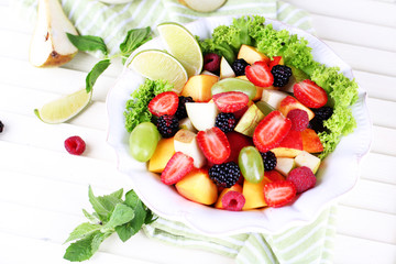 Fruit salad in plate on wooden table
