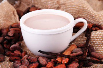 Cocoa drink and cocoa beans on sackcloth  background