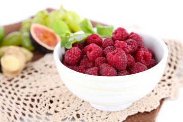 Raspberries in small bowl on napkin isolated on white