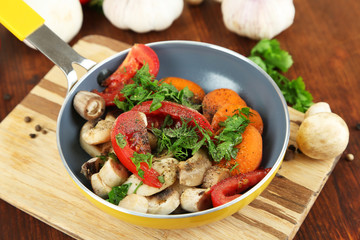 Sliced fresh vegetables in pan on wooden table close-up