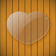 Glass plate in the form of heart on the background of wooden wal