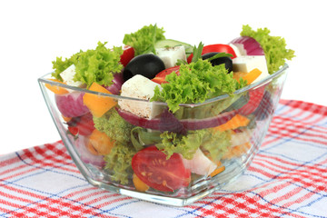 Greek salad on plate on table on white background