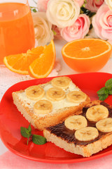 Delicious toast with bananas on plate close-up