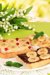 Delicious toast with bananas on plate close-up