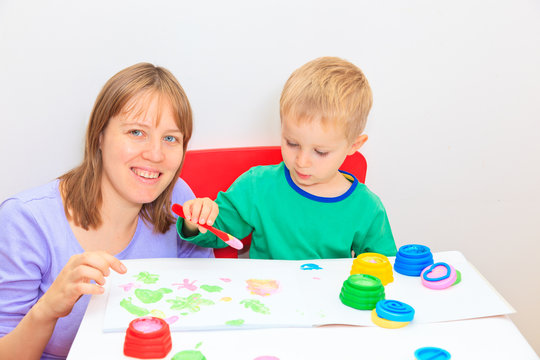 Child with teacher drawing in playroom
