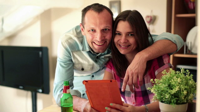 Happy couple with tablet at home