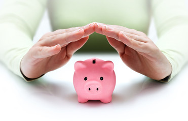 protect your savings - with his hands covering the piggy bank