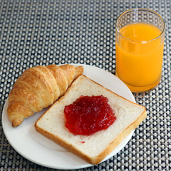 strawberry jam on bread, croissant  and orange juice