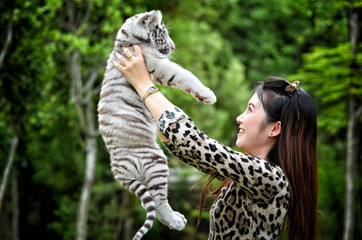 women hold baby white bengal tiger
