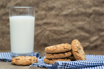 Rustic setting with chocolate chip cookies and glass of milk