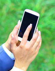 Woman using mobile smart phone in the park.