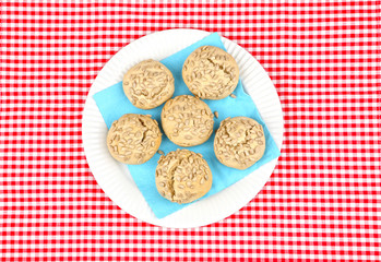 white plate on checked tablecloth filled with buns